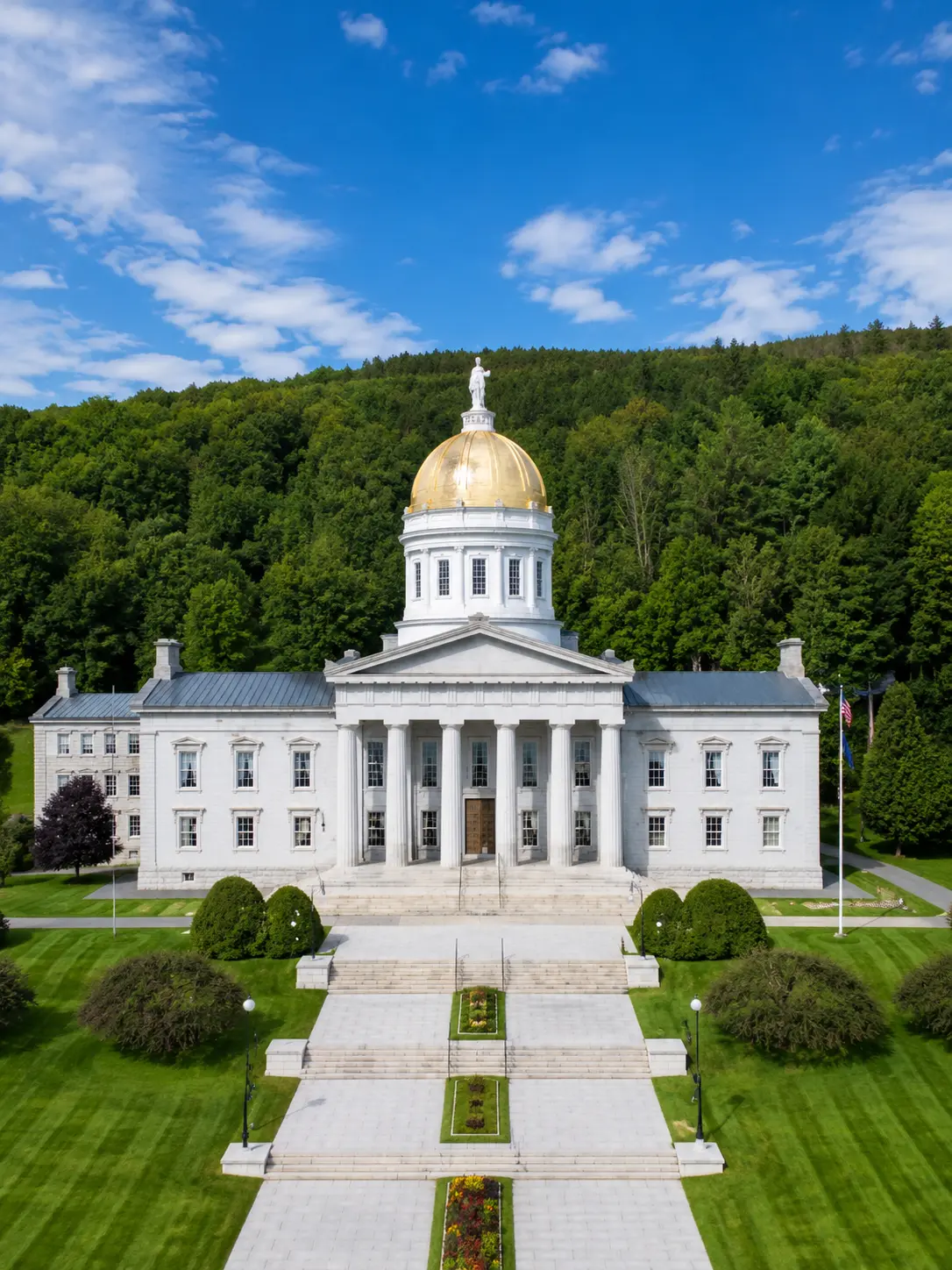 Vermont State House at sunrise, gold dome above autumn foliage in the Northeast
